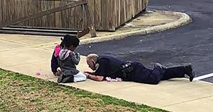 Officer Responding To Emergency Call Plays With Dolls On The Street To Help Keep Children Calm Officer Responding To Emergency Call Plays With Dolls On The Street To Help Keep Children Calm