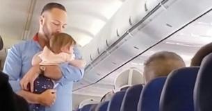 Un membre de l'équipage s'approche d'une famille qui n'arrive pas à calmer les pleurs de son enfant à bord de l'avion et se charge de la situation Un membre de l'équipage s'approche d'une famille qui n'arrive pas à calmer les pleurs de son enfant à bord de l'avion et se charge de la situation