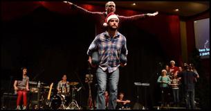 2 Men Standing On Stage For Christmas Skit. The Crowd Is Rolling With Laughter At The Unexpected Twist 2 Men Standing On Stage For Christmas Skit. The Crowd Is Rolling With Laughter At The Unexpected Twist